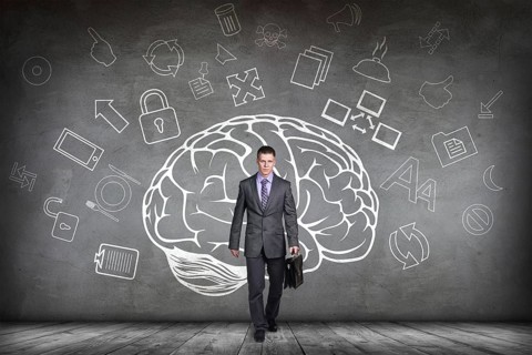 Woman stands beside big drawn brain on the gray wall