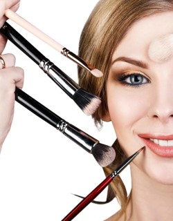 Many hands with cosmetics brushes applying make-up to glamour woman, over white background
