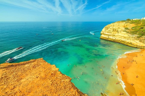 Aerial view of golden cliffs of Praia de Benagil in Algarve near Lagoa, Portugal, Europe. Boat