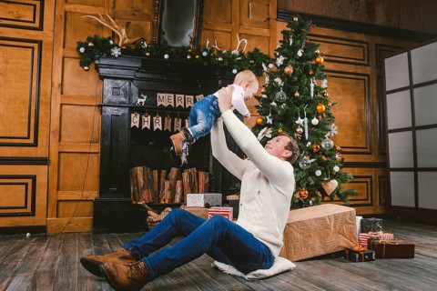 Happy father and son at home near Christmas tree. New Year and Christmas theme. Holiday mood.