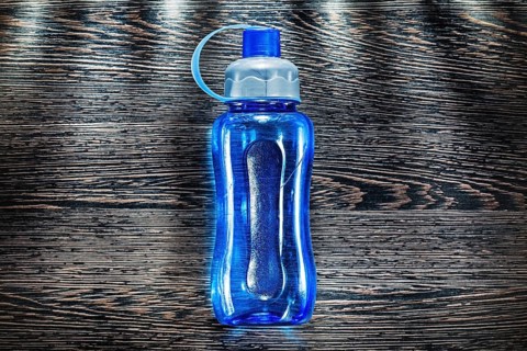 Plastic water shaker on vintage wooden board