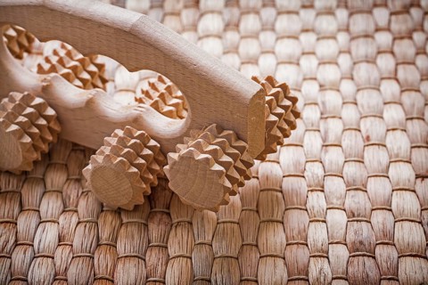 Close up image of wooden relaxing massager on wicker background healthcare concept