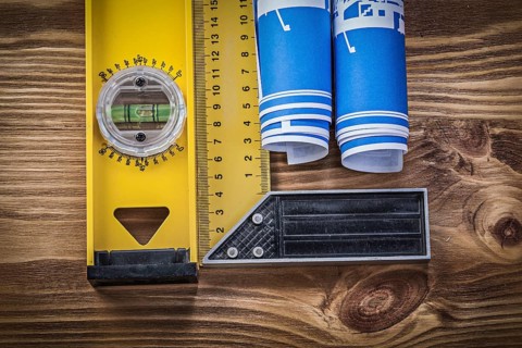Blue engineering drawings construction level square ruler on wooden board