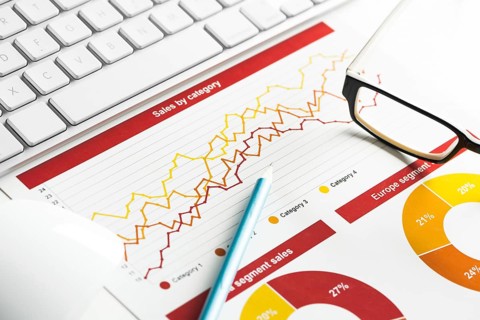 Business workplace with keyboard mouse and papers with graphs and diagrams