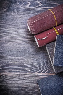Rough abrasive paper sponges on vintage wood board construction concept