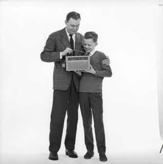 In the 1960s. Father and son with a radio. It's a typical 1960s radio with a cover of perforated