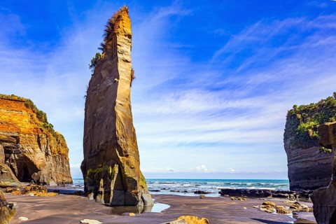 Amazing rock formations on Tongaporutu beach. Pacific coast. New Zealand. Narrow strip of sand