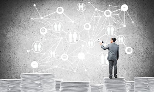 Businessman with speaker in hand standing on pile of documents with social network structure on