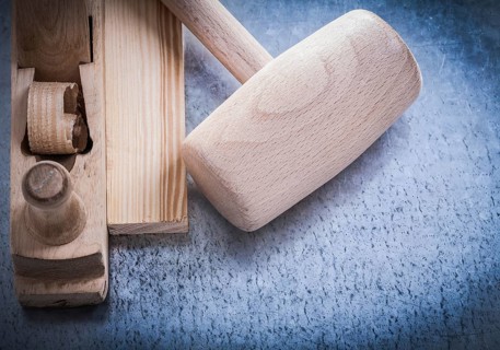 Planer lump hammer wooden brick on metallic background construction concept