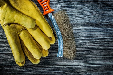 Wire brush safety gloves on vintage wooden board