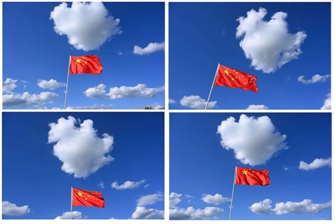 The flag of China flutters in the wind in a blue sky with white clouds
