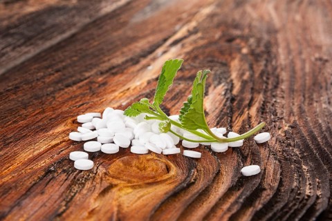 Artificial sweetener pills with aztec sweet herb on wooden table