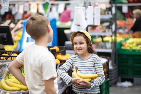 Kids little cute girl and teenager boy shopping for fresh organic fruits bananas and vegetables in