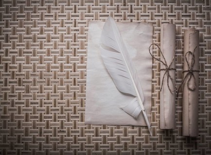 Rolls of vintage paper clean sheet quill on wicker mat
