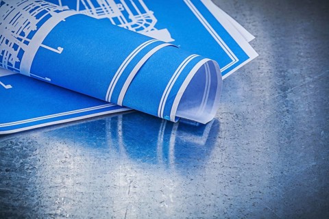 Blue blueprints on scratched metallic background construction concept