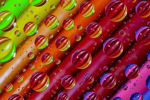 Color pencils under glass with drops of water. Office concept