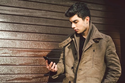 Portrait of young handsome Turkish male model of Mediterranean race brunet in leather coat using