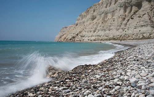 Empty pebble tropical beach under white cliffs against blue sky. Pissouri coastline Limassol Cyprus