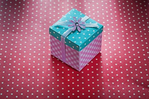 Present box on red polka-dot table cloth celebrations concept