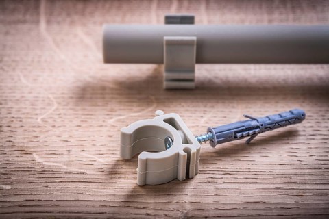 Close Up Pipe With Clips And Polypropylene Fixator On Wooden Board