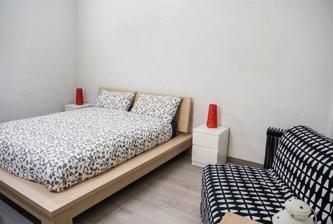 Small cozy bedroom interior furnished with comfortable soft bed and chair in contemporary apartment