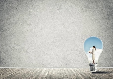 Businesswoman inside of light bulb in empty concrete room