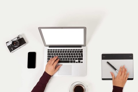 Clean and modern workplace. Notebook, coffee, graphic tablet, phone, camera and to do list and
