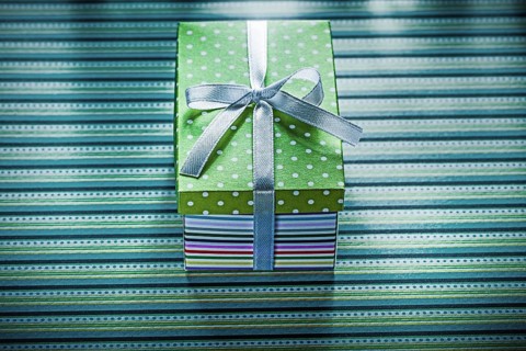 Present box on striped background holidays concept