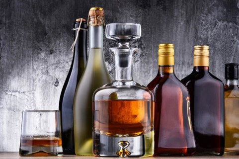 Composition with carafe and bottles of assorted alcoholic beverages
