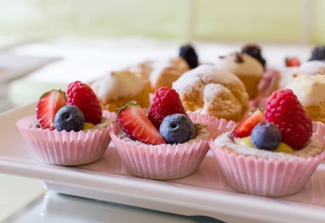 Close up of fresh and tasty cakes with fruits and berries