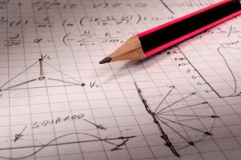 Pencil on notebook, full of mathematical formulas