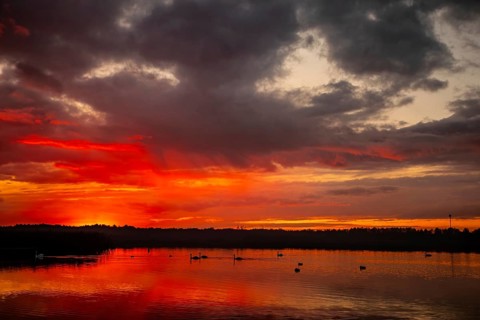 A breathtaking sunset captivatingly painting the sky with vibrant colors that shimmer over tranquil