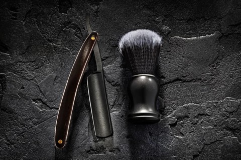Black Barber Tools. Shaving Brush And Opened Straight Razor With Classic Wooden Handle On Abstract