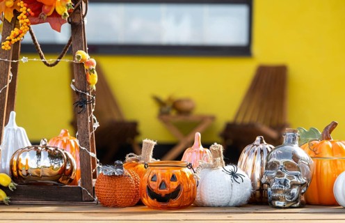 Autumn decor on the porch of the house outside in the yard of pumpkin, lantern, garlands, hats,
