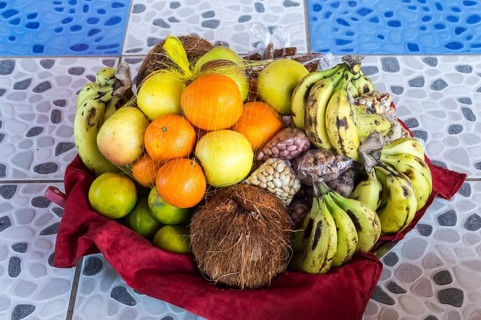 Colorful fresh fruits mixed in the basket lay on the tiling