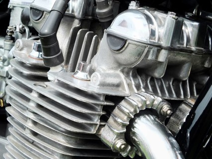 Close up detail of the engine of an old vintage motorcycle with black frame and shiny chrome