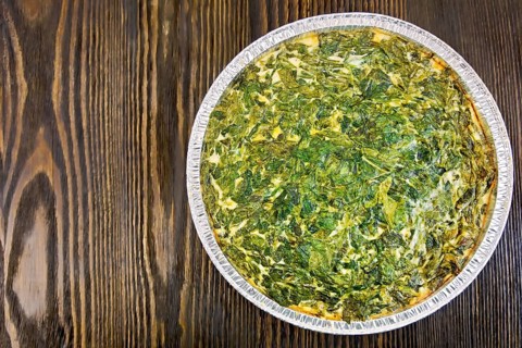 Celtic cake with spinach, tomatoes, oatmeal and eggs in baking dish from a foil against the
