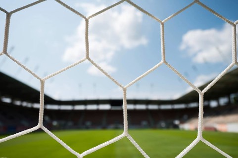 Net on a soccer goal and stadium in the background in Lubin, Poland