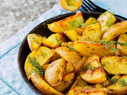 Close up view of backed potatoes in cast iron skillet