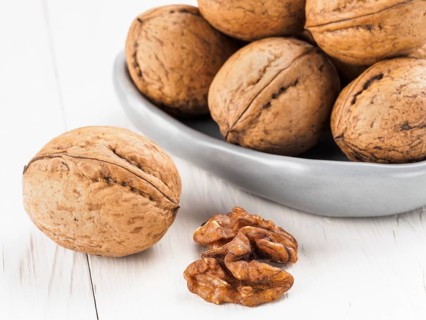Inshell walnut on white wooden background
