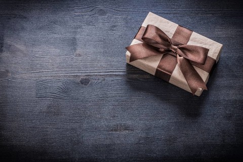 Present box-container with bow on vintage wooden board