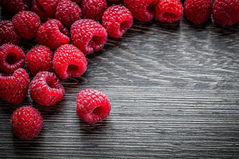 Heap of raspberries on wooden background
