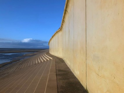 Perspective view of the concrete seawall in blackpool with steps leading down to the beach in warm