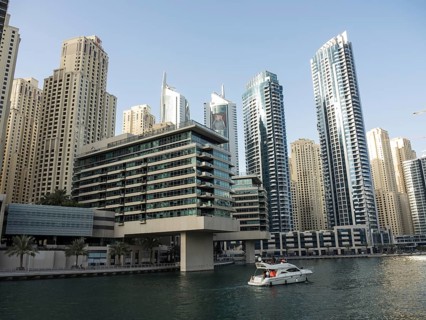 Modern skyscrapers on the riverbank with a boat on the water, impressive skyline of a modern city