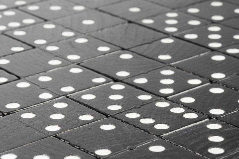 Composition of lying black domino bricks with white dots