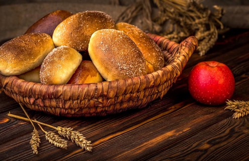 Ukrainian baked pies in wicker basket on wooden table