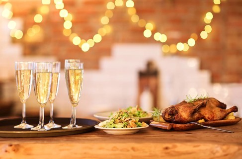Winter holiday family dinner with roast poultry and champagne
