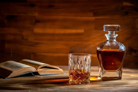 A glass of rum and an old book in a bar in Cuba
