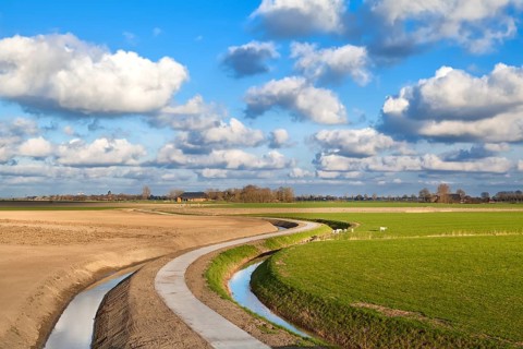 Curved road under blue sky with nice cloudscape, Netherlands