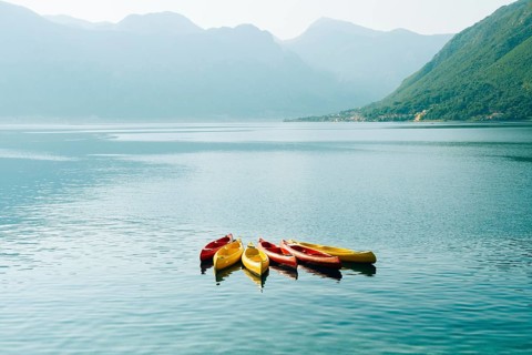 Kayaks moored in the water. Empty kayaks without people. In the Bay of Kotor, in Montenegro
